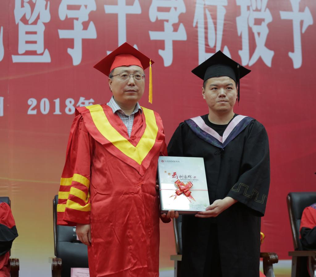校党委书记穆瑞杰代表学校接受毕业生赠送的纪念册《云树春晖》
